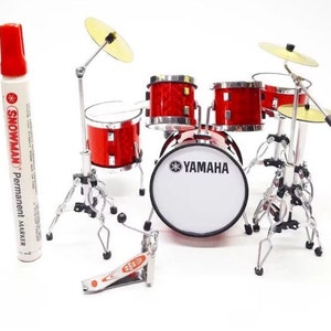 May include: A miniature red drum kit with a Yamaha bass drum, cymbals, and a foot pedal. The drum kit is on a white background.