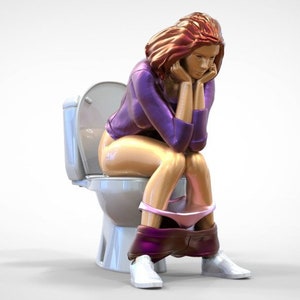 Könnte beinhalten: Eine Frau in einem lila Shirt und rosa Unterwäsche sitzt auf einer weißen Toilette. Sie hat rote Haare und schaut nach unten.
