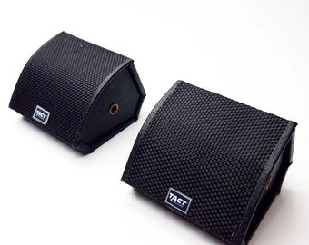 May include: Two black speaker cabinets with a black mesh grille and the word "TACT" printed on the front.