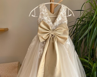 Abito da damigella in tulle con applicazioni in pizzo e fiocco grande.