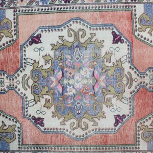 May include: A vintage rug with a central medallion design in shades of blue, green, and pink. The rug has a faded, distressed look and features intricate floral and geometric patterns.