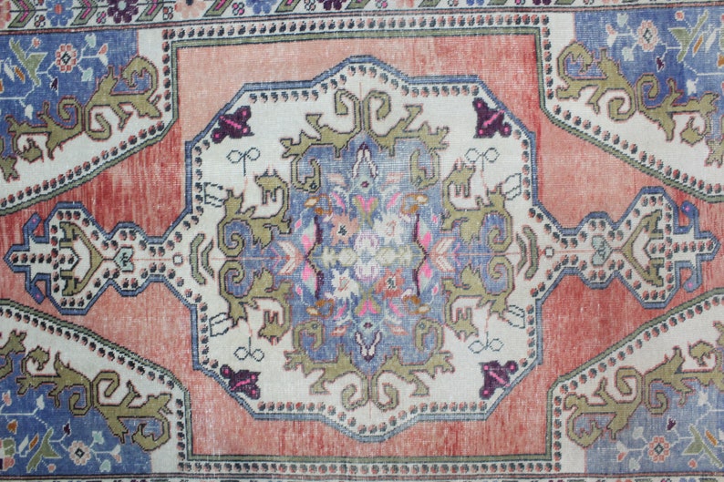 May include: A vintage rug with a central medallion design in shades of blue, green, and pink. The rug has a faded, distressed look and features intricate floral and geometric patterns.