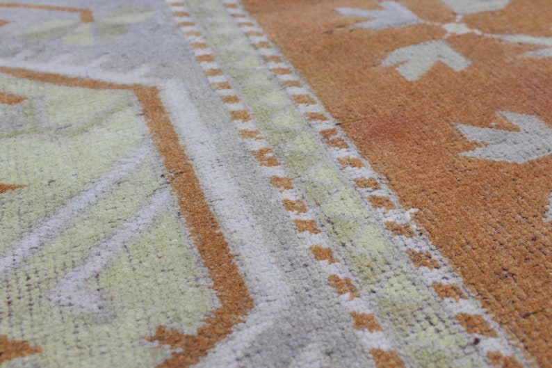 May include: Close-up of a woven rug with a geometric pattern in shades of brown, beige, and white.