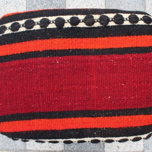 May include: Red, black, and white striped woven cushion with a black and white beaded trim.