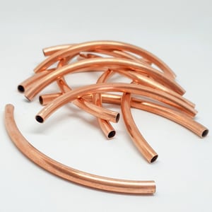 Könnte beinhalten: Zehn Kupferrohrsegmente, die jeweils zu einer Halbkreisform gebogen sind. Die Segmente sind in einem Stapel angeordnet, wobei sich einige überlappen.