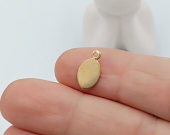 May include: Gold oval charm with a loop at the top. The charm is smooth and has a shiny finish.