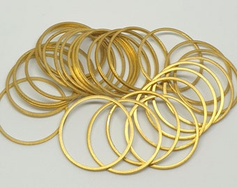 May include: A pile of gold-colored metal rings, each with a smooth, rounded surface. The rings are stacked and overlapping, creating a visually appealing pattern.