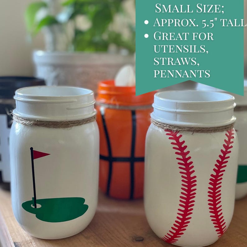 May include: White mason jars with sports-themed designs, including a golf flag, a baseball with red stitching, and a basketball. Each jar is approximately 5.5 inches tall and wrapped with twine. The text on the image says "Small Size" and "Great for utensils, straws, pennants."
