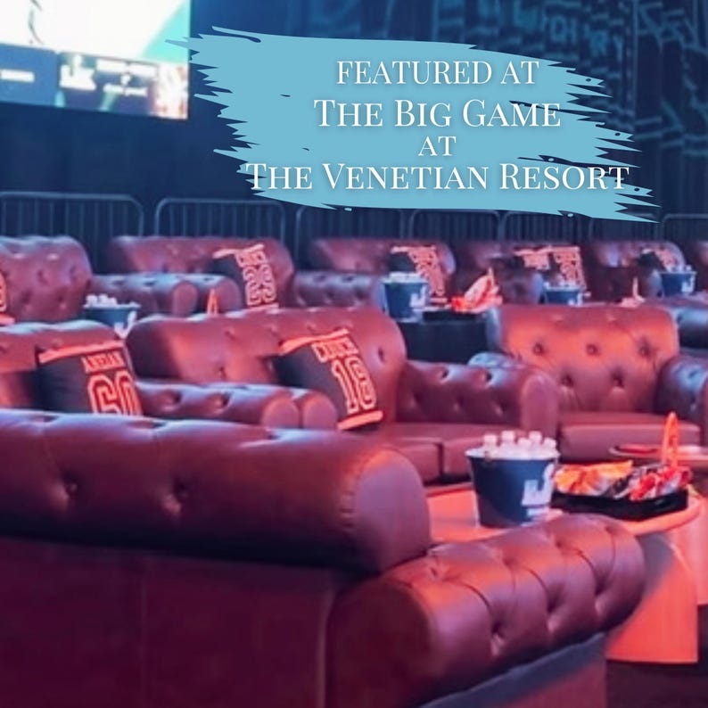 May include: A row of dark brown tufted leather sofas with button detailing, each featuring small rectangular pillows with jersey-style numbers. A light blue graphic overlay reads: FEATURED AT THE BIG GAME AT THE VENETIAN RESORT.