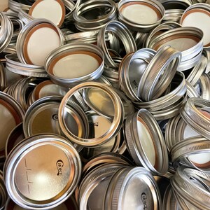 May include: A pile of silver metal jar lids with a white rubber seal. The lids have a raised rim and a small, black "Choice" logo.