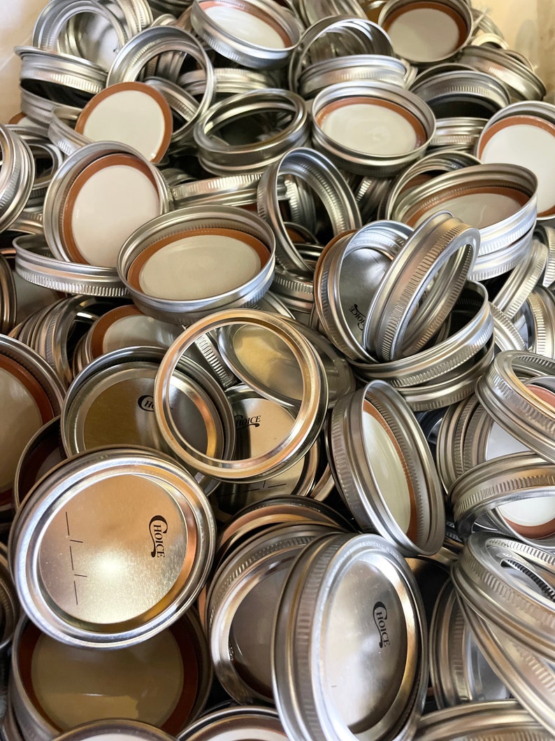 May include: A pile of silver metal jar lids with a white rubber seal. The lids have a raised rim and a small, black "Choice" logo.