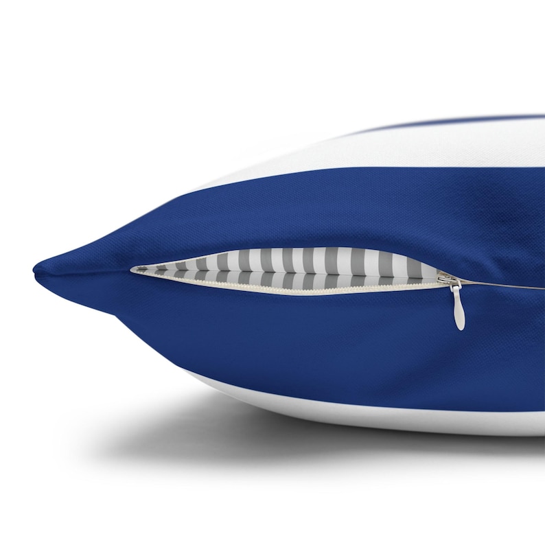 May include: A square throw pillow featuring wide horizontal stripes in deep royal blue and crisp white. The pillow includes a concealed zipper closure along the side, revealing a subtle grey and white pinstriped fabric lining inside the seam.
