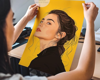 Könnte beinhalten: Eine Frau hält ein Poster mit einer digitalen Illustration einer Frau mit braunen Haaren und einem schwarzen Oberteil vor einem gelben Hintergrund. Das Poster trägt den Text "FDN PREMIUM MOCKUP STUDIO" oben.