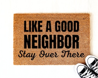 May include: A brown coir doormat with the text "Like a good neighbor Stay over there" in black lettering.