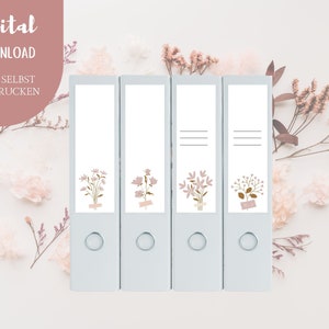 Può includere: Quattro raccoglitori ad anelli azzurri con disegni floreali e le parole "Digital Download" e "Zum Selbst Ausdrucken". I disegni floreali sono nei toni del rosa, marrone e verde e sono attaccati ai raccoglitori.
