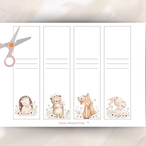 May include: A sheet of printable bookmarks featuring watercolor illustrations of woodland animals: a hedgehog, bear, fox, and bunny, each adorned with floral crowns. The design includes dotted lines for cutting and horizontal lines for writing. A pair of scissors is in the upper left corner.