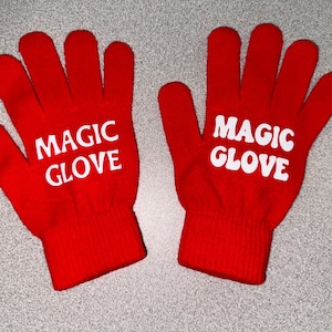 May include: A pair of red knit gloves with the text "MAGIC GLOVE" in white letters on each glove.