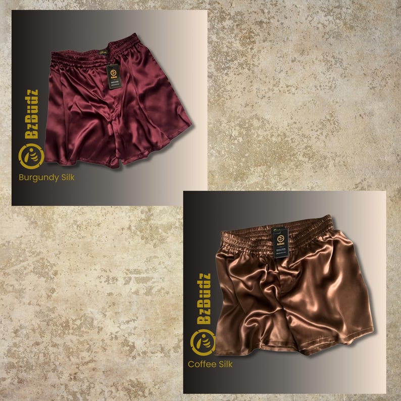 May include: Two pairs of satin shorts in burgundy and coffee colors. The shorts have an elastic waistband and a relaxed fit. The brand name "BzBuddz" is printed on the shorts.