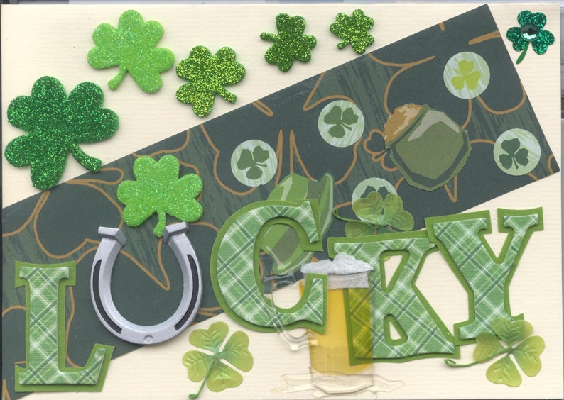 May include: A green and white card with the word "LUCKY" spelled out in green and white plaid letters. The card is decorated with shamrocks, a horseshoe, and a glass of beer.