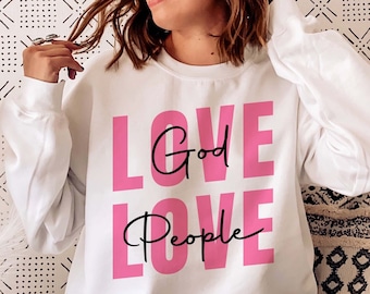 May include: White sweatshirt with the words "Love God Love People" printed in pink.