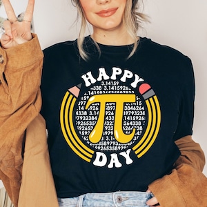 May include: A black t-shirt with a yellow circle design featuring the mathematical constant pi and the text "Happy Pi Day".