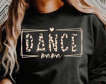 May include: Black sweatshirt with the words "DANCE mama" in a rectangular frame. The word "DANCE" has a leopard print pattern. A small heart is above the word "DANCE".