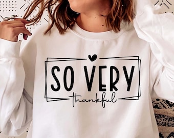 May include: White sweatshirt with black text that reads "SO VERY thankful" inside a black frame with a small heart above the text.