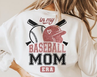 Può includere: Felpa bianca con una grafica di baseball in glitter rosa e il testo "in my baseball mom era".