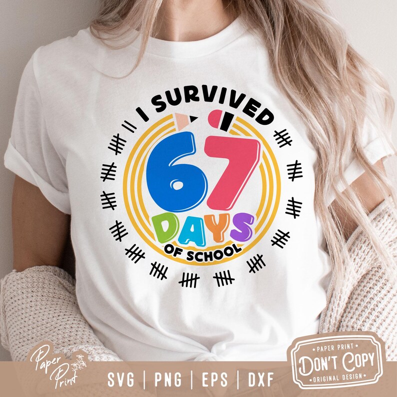 May include: White t-shirt with a colorful graphic that reads "I SURVIVED 67 DAYS OF SCHOOL." The design includes a blue "6", a pink "7", and the word "DAYS" in green and purple. The shirt has a round neck and short sleeves.