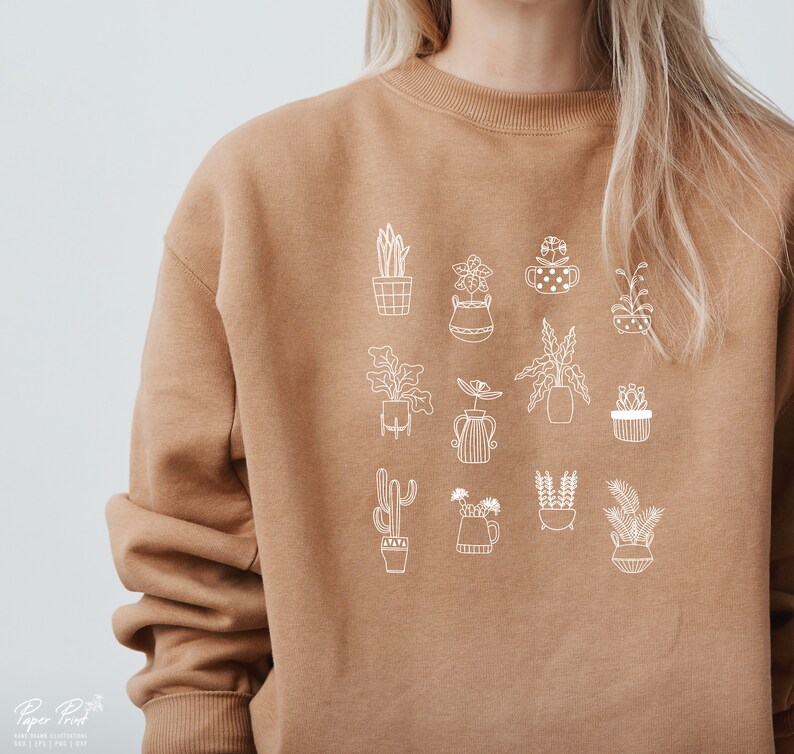 May include: A brown sweatshirt with a white outline design of various potted plants. The design includes cacti, succulents, and leafy plants.