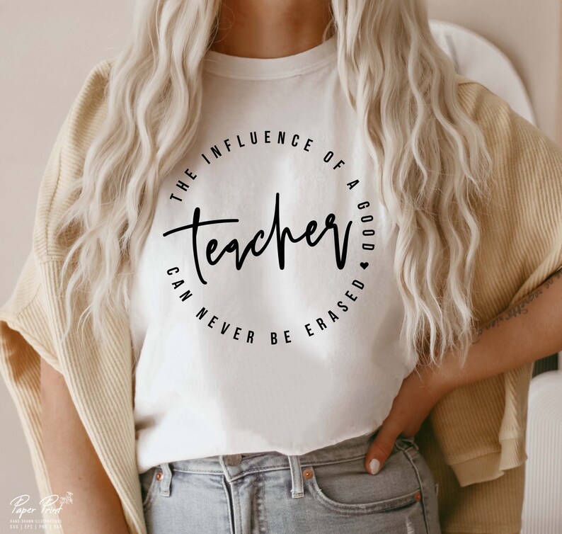 May include: White t-shirt with a black circle graphic that says "The influence of a good teacher can never be erased".
