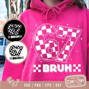 Könnte beinhalten: Ein pinkfarbener Kapuzenpullover mit einem weiß karierten "67"-Motiv und dem Wort "BRUH" in einer karierten Schriftart. Zwei kreisförmige Designs mit demselben Motiv befinden sich links. Der Hoodie hat eine Kapuze mit Kordelzug.
