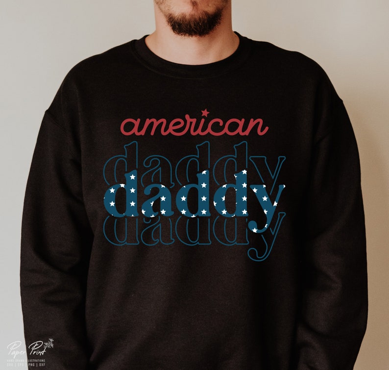 Puede incluir: Sudadera negra con el texto "american daddy" en rojo y azul con estrellas blancas. La palabra "daddy" se repite tres veces, cada repetici&oacute;n es m&aacute;s peque&ntilde;a.