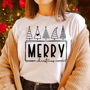 May include: White t-shirt with a black and white graphic of Christmas trees and the text "Merry Christmas".