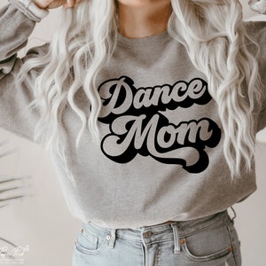 Peut inclure: Un sweat-shirt gris avec le texte "Dance Mom" en lettres r&eacute;tro noires.