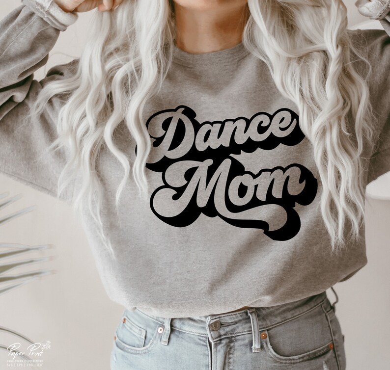 Peut inclure: Un sweat-shirt gris avec le texte "Dance Mom" en lettres r&eacute;tro noires.