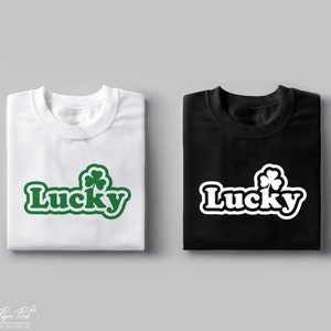 May include: Two t-shirts, one white and one black, with the word "Lucky" in a retro font and a green four-leaf clover graphic.