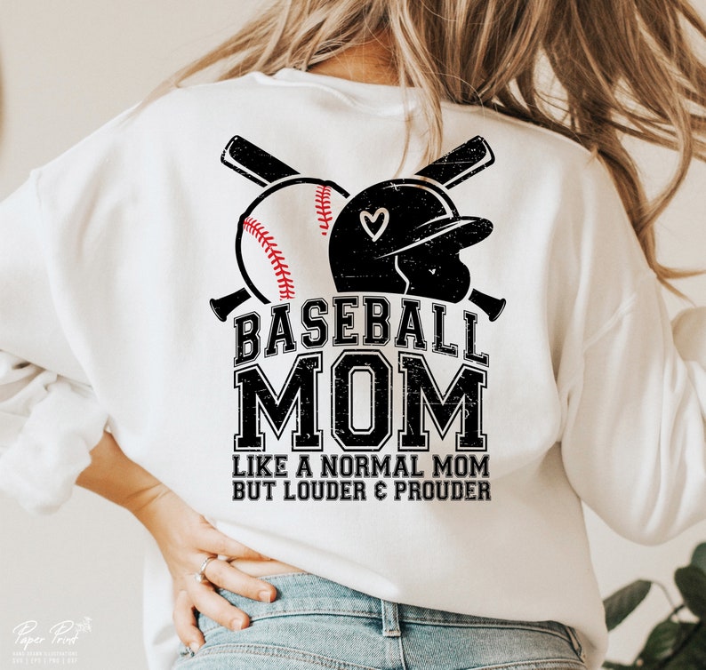 以下が含まれることがあります： 白地に黒と白の野球のグラフィックと「Baseball Mom Like a Normal Mom But Louder & Prouder」というテキストが書かれた白いスウェットシャツ。