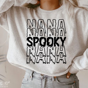 May include: A gray sweatshirt with a black graphic that says "NANA SPOOKY NANA" in dripping letters.