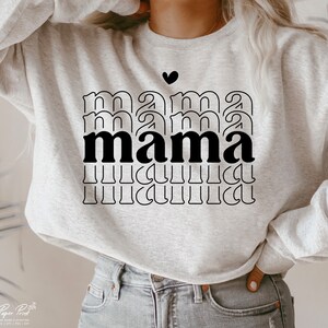May include: A gray sweatshirt with the word "mama" printed in black letters. The word is repeated multiple times, with each repetition getting smaller. A small black heart is above the word.