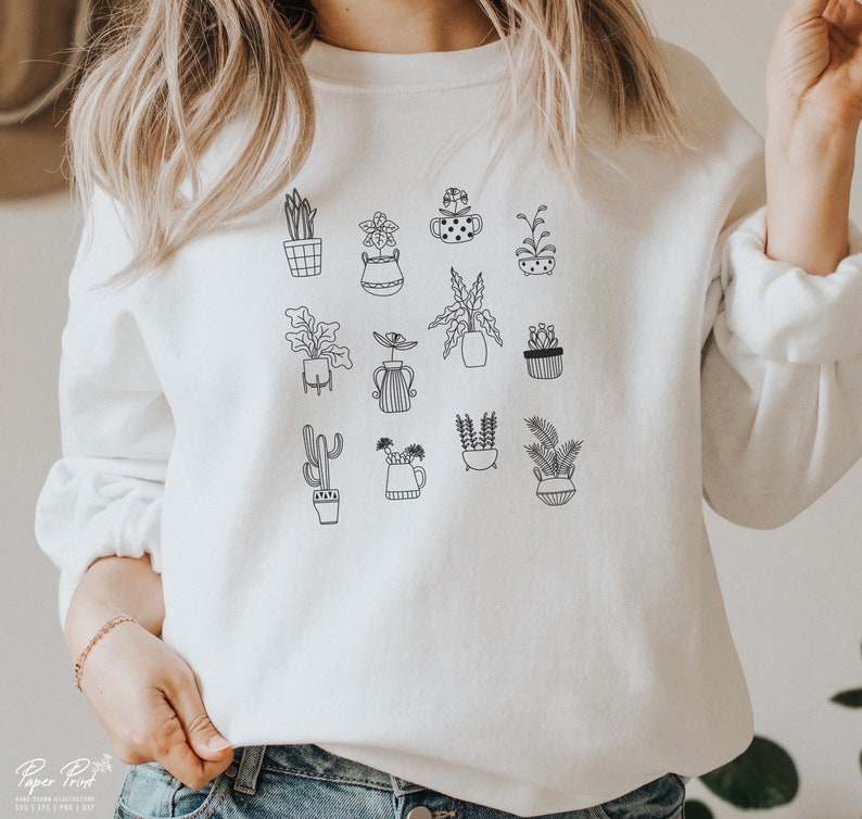 May include: White sweatshirt with a black line drawing of various potted plants. The plants include cacti, succulents, and leafy plants.