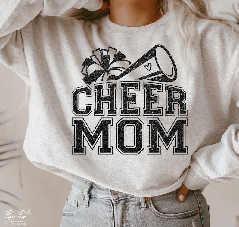 May include: A grey sweatshirt with a black glitter design that says "Cheer Mom" with a cheerleader megaphone and pom poms.