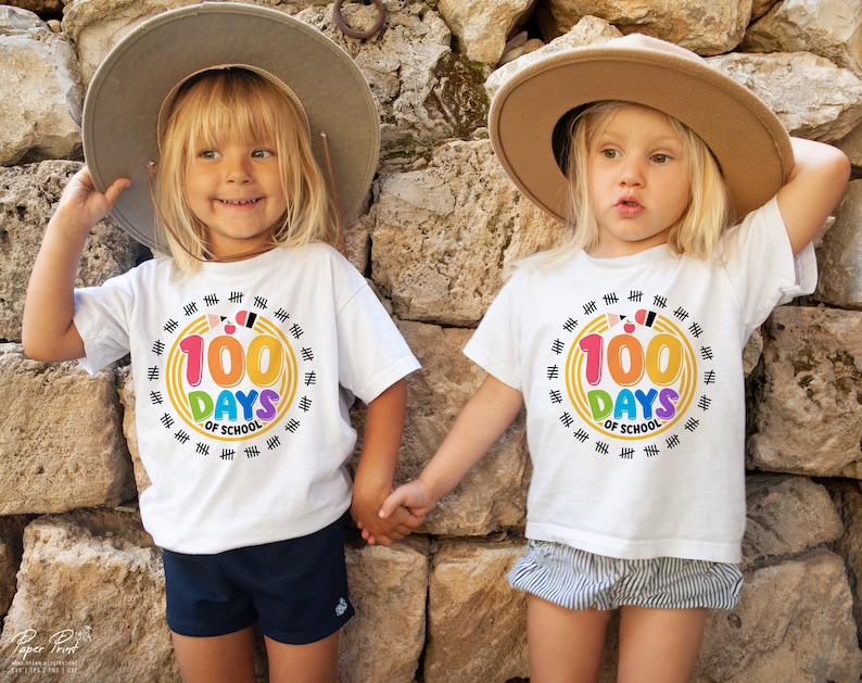 May include: Two children wearing white t-shirts with a colorful graphic that says "100 Days of School" and a circle of tally marks around it. The children are wearing straw hats and smiling.