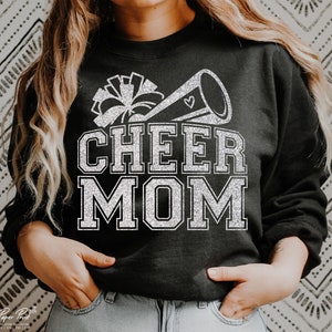 May include: Black sweatshirt with a silver glitter design of a cheerleader megaphone and the words "CHEER MOM".