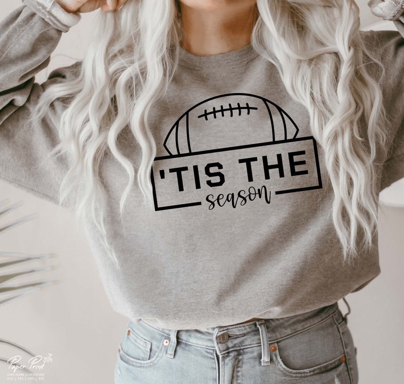 May include: A gray sweatshirt with a black outline of a football and the text 'Tis the season'.