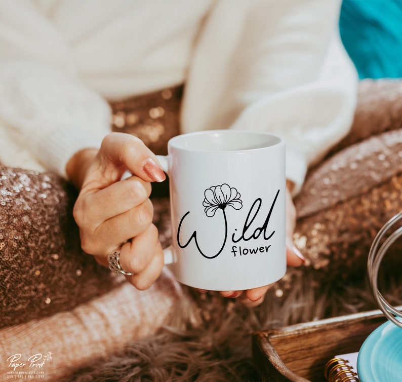 May include: White ceramic mug with a black design of a flower and the text "Wild flower".