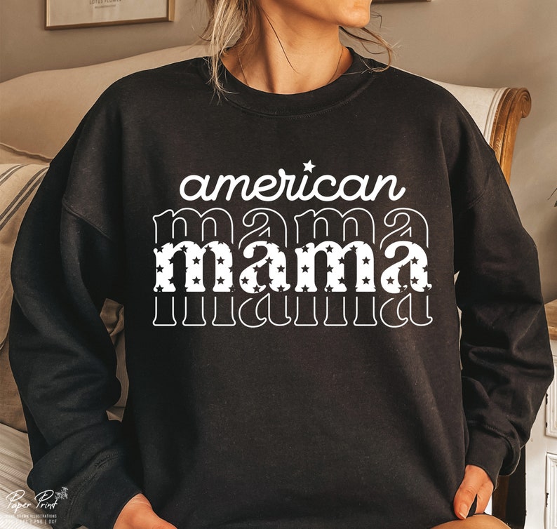 Pode incluir: Camisola de moletom preta com texto branco que diz "american mama" com a palavra "mama" em uma fonte retr&ocirc; e cheia de estrelas brancas.