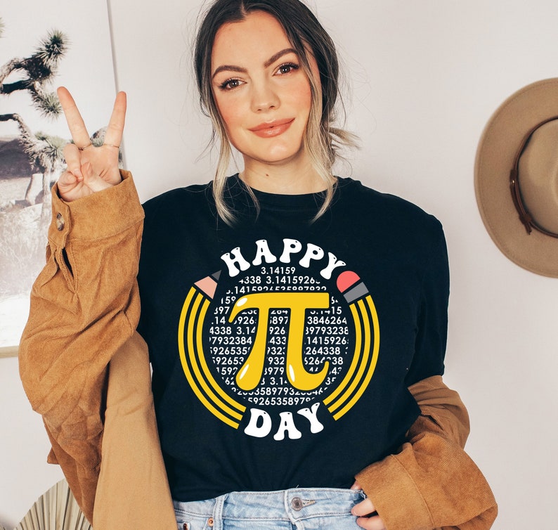May include: A black t-shirt with a yellow circle design featuring the mathematical constant pi and the text "Happy Pi Day".