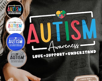 May include: A black t-shirt with the word "AUTISM" in rainbow colors and the text "Awareness - LOVE #SUPPORT #UNDERSTAND". The shirt also has a heart with puzzle pieces in the colors of the rainbow.