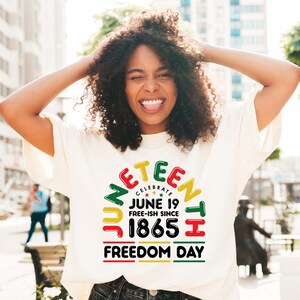 May include: A white t-shirt with a colorful graphic design that says "Juneteenth Celebrate June 19 Free-ish Since 1865 Freedom Day".